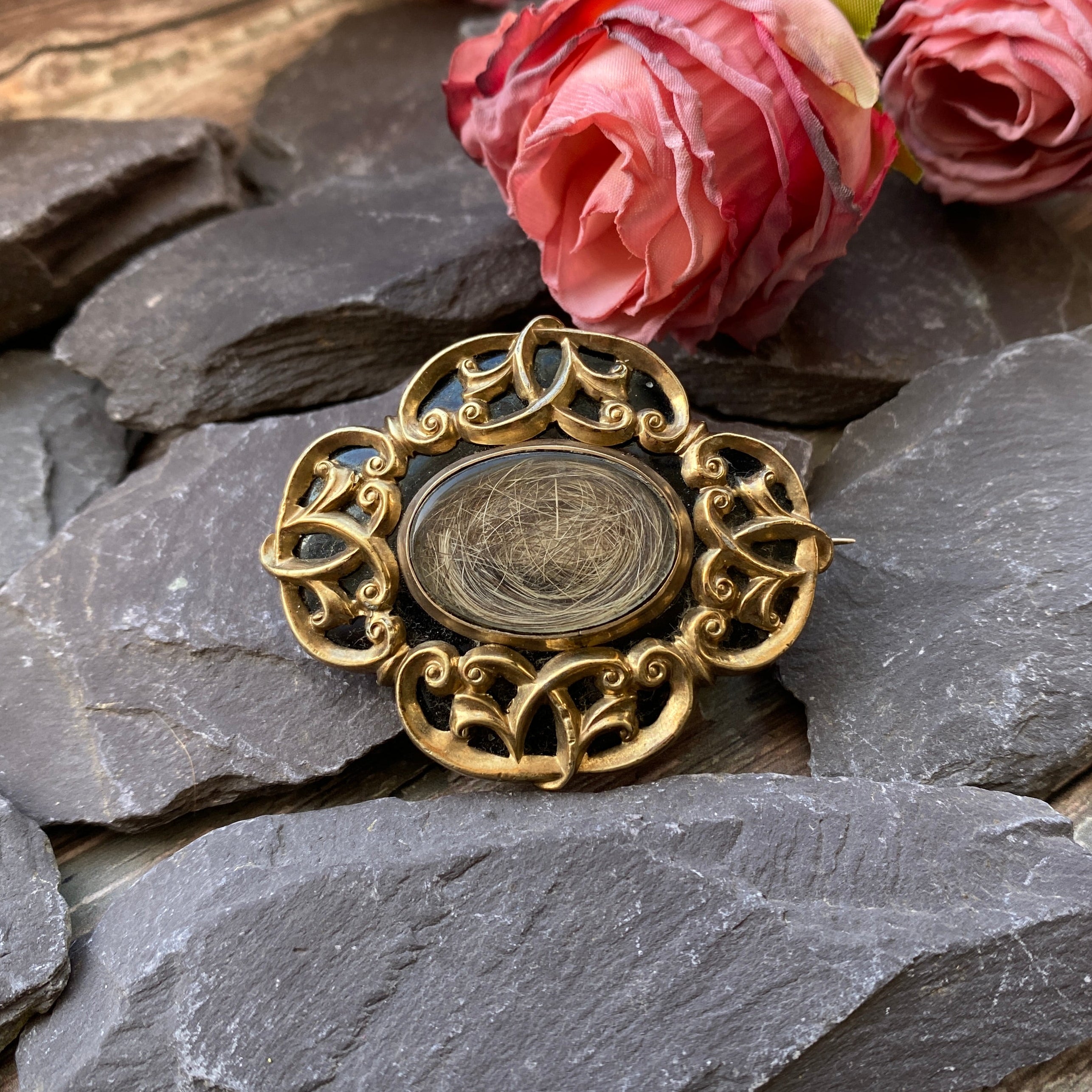 Victorian gold mourning brooch with black enamel and hair locket.