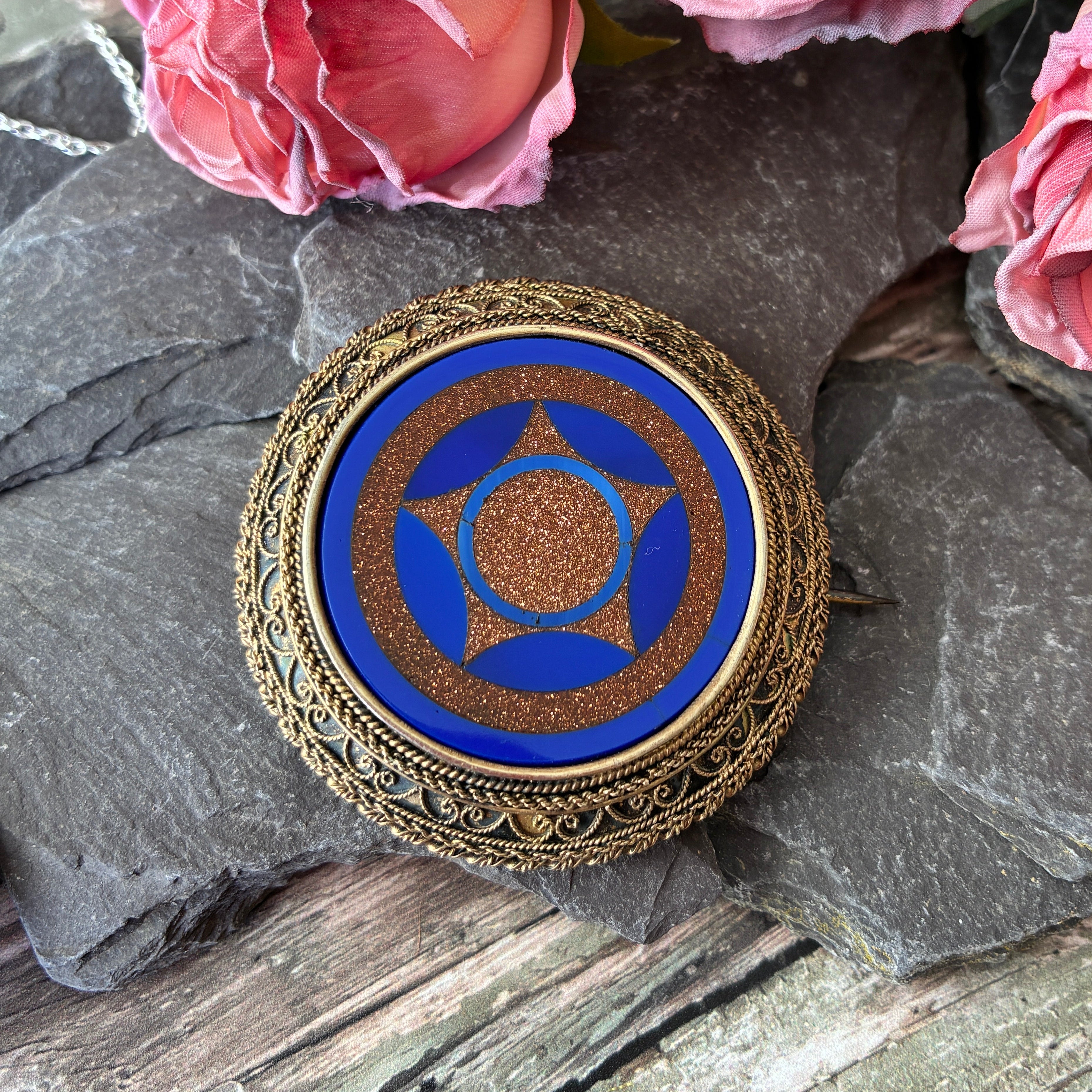 Victorian silver gilt brooch in the Etruscan style inlaid with blue and gold glass.