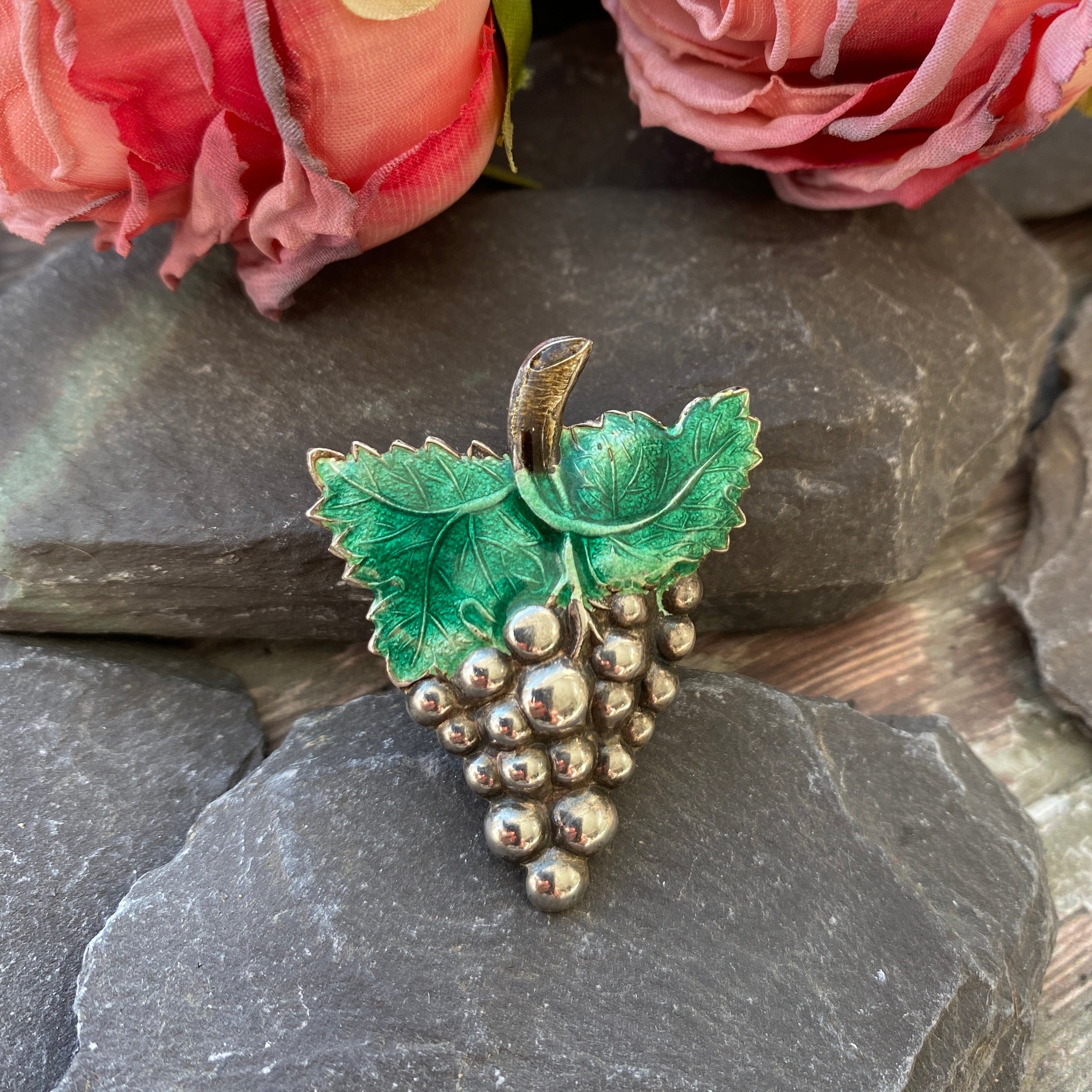Silver grape brooch with green enamel leaves