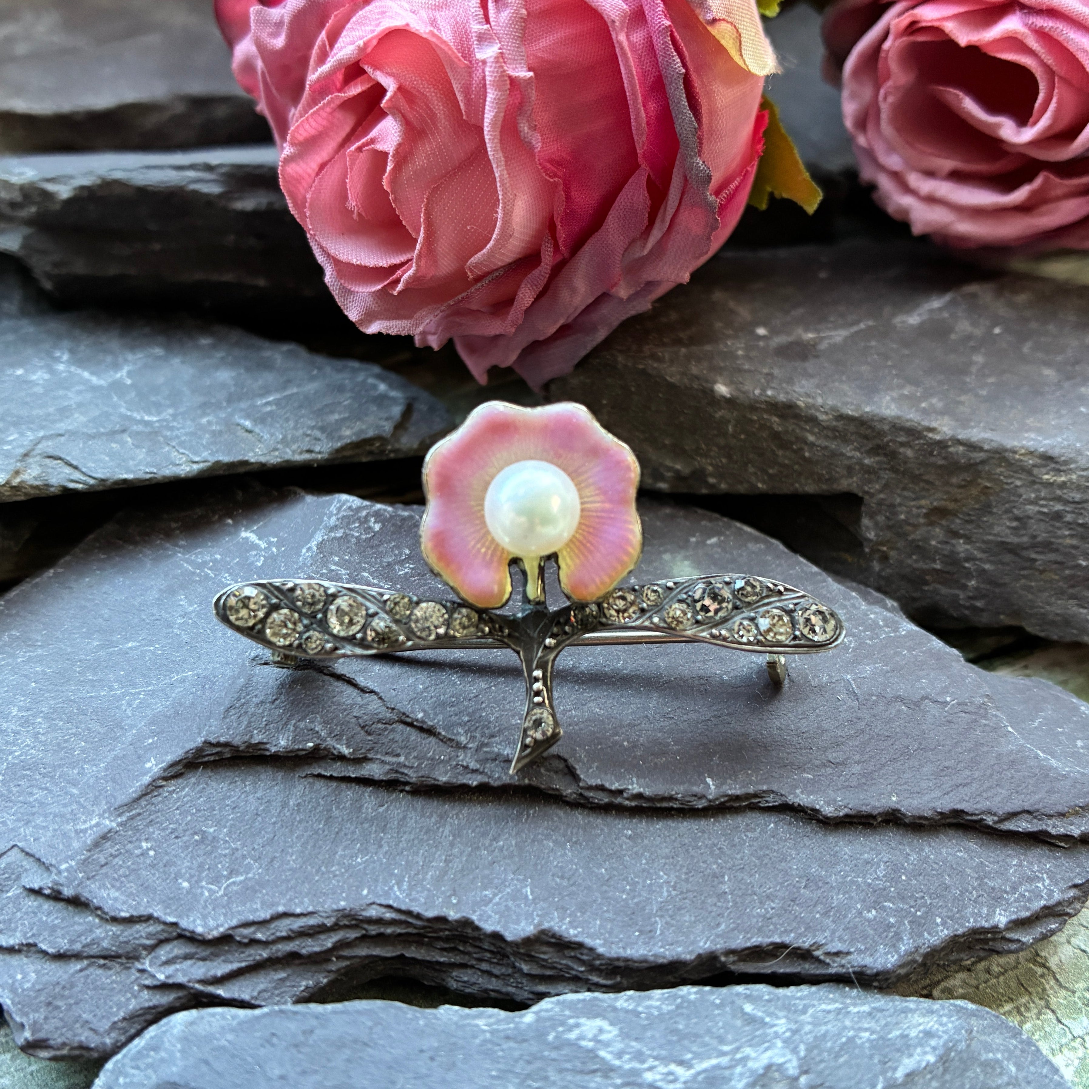 Early 20th century silver brooch set with paste with pink enamel flower and cultured pearl centre.